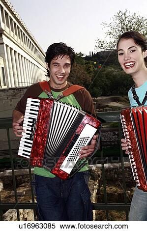 Stock Photography - Couple at archaeological site playing accordion. Fotosearch