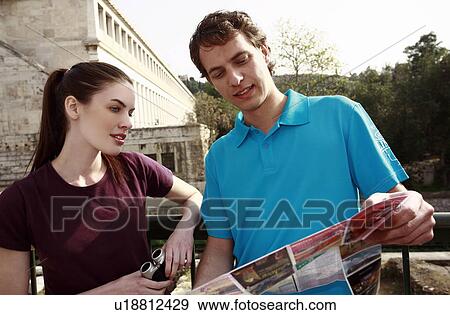 Couple at archaeological site reading map View Large Photo Image Stock Photo - Couple at archaeological site reading map. Fotosearch