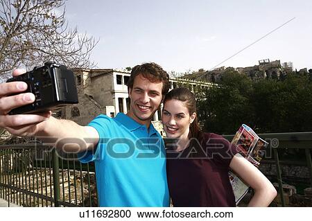 Stock Image - Couple at archaeological site photographing themselves. Fotosearch