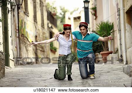 Stock Photo - Couple with Greek costume hats dancing. Fotosearch