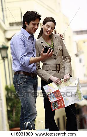 Couple with map looking at digital camera View Large Photo Image Stock Image - Couple with map looking at digital camera. Fotosearch