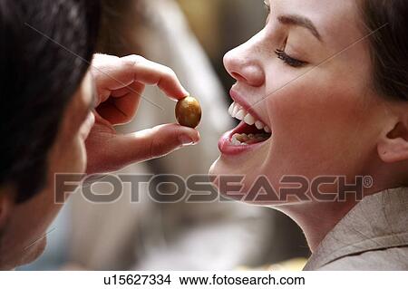 Picture - Man feeding woman an olive. Fotosearch