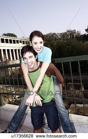 Stock Photo - Man giving woman a piggy back ride. Fotosearch