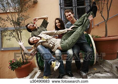 Two couples playing around on a bench View Large Photo Image Stock Image - Two couples playing around on a bench. Fotosearch
