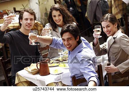 Picture - Two couples toasting their wine glasses. Fotosearch