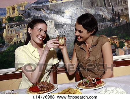 Two women toasting over souvlaki View Large Photo Image Stock Photo - Two women toasting over souvlaki. Fotosearch