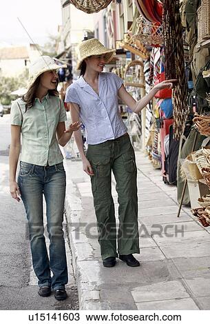 Stock Image - Two women wearing hats shopping. Fotosearch