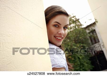 Woman looking from behind a wall View Large Photo Image Stock Photo - Woman looking from behind a wall. Fotosearch