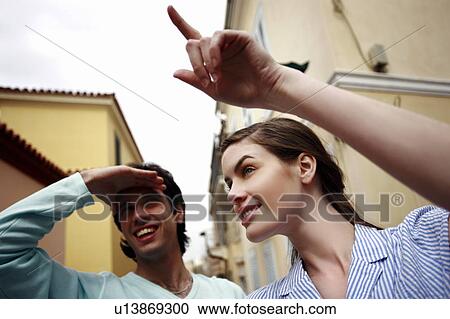 Stock Image - Woman pointing to show man the way. Fotosearch