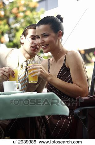 Business couple in garden cafe drinking orange juice View Large Photo Image Stock Photography - Business couple in garden cafe drinking orange juice. Fotosearch