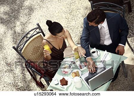 Picture - Business couple in garden cafe with laptop. Fotosearch