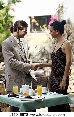 Businessman and businesswoman in garden cafe shaking hands View Large Photo Image Stock Photo - Businessman and businesswoman in garden cafe shaking hands. Fotosearch