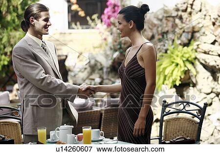 Businessman and businesswoman in garden cafe shaking hands View Large Photo Image Stock Photo - Businessman and businesswoman in garden cafe shaking hands. Fotosearch