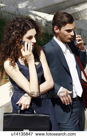 Businessman and businesswoman on cell phones View Large Photo Image Stock Photo - Businessman and businesswoman on cell phones. Fotosearch