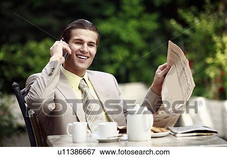 Businessman in garden cafe with cell phone View Large Photo Image Stock Photo - Businessman in garden cafe with cell phone. Fotosearch
