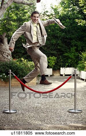 Businessman in garden jumping over barrier View Large Photo Image Stock Photography - Businessman in garden jumping over barrier. Fotosearch