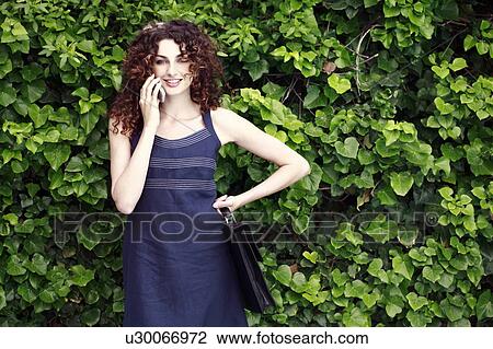 Businesswoman on cell phone in garden View Large Photo Image Stock Image - Businesswoman on cell phone in garden. Fotosearch