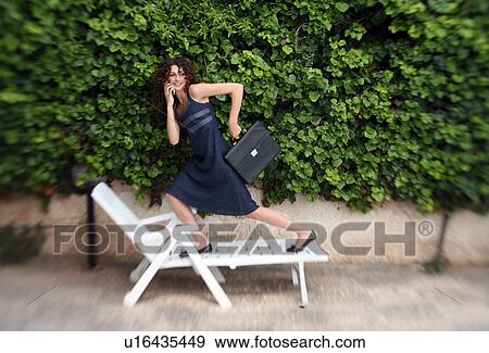 Stock Photo - Businesswoman running on chaise lounge. Fotosearch