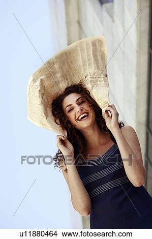 Picture - Happy businesswoman with newspaper on head. Fotosearch