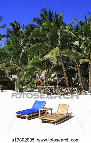 Stock Photography - Beach chairs and table on the beach. Fotosearch