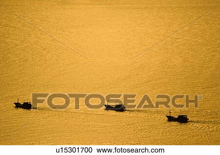 Stock Image - Boats running at the sunset, Sanya City, Hainan Province, China. Fotosearch