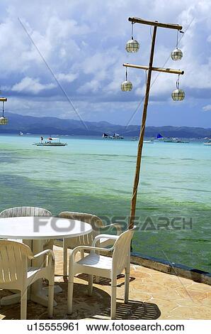 Stock Image - Dinner table and chairs laying up seaside. Fotosearch