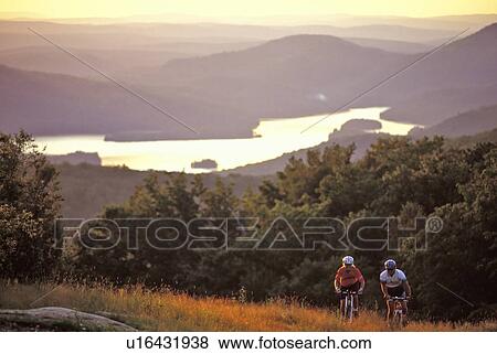 Couple mountain biking on Mont Tremblant at sunset, Quebec, Canada View Large Photo Image Stock Photo - Couple mountain biking on Mont Tremblant at sunset, Quebec, Canada. Fotosearch
