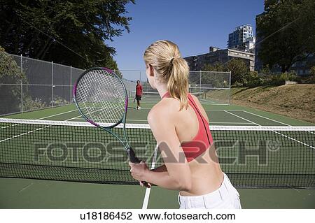 Stock Image - Couple playing tennis; Canada, British Columbia, Vancouver. Fotosearch