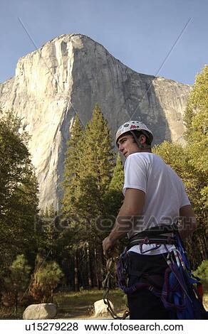 Stock Photo - Man (20-25) standing in front of El Capitan in Yosemite National Park, USA. Fotosearch