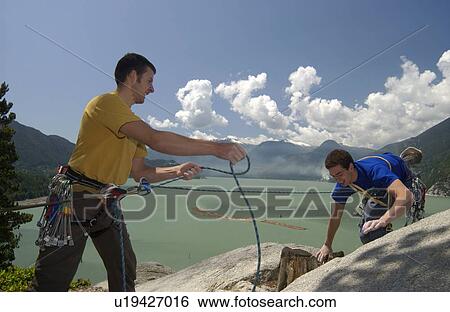 Two Men (20-25) Rock climbing. One climber belays the other as a safety measure, Stawamus Chief Provincial Park, Squamish, BC, Canada View Large Photo Image Stock Photograph - Two Men (20-25) Rock climbing. One climber belays the other as a safety measure, Stawamus Chief Provincial Park, Squamish, BC, Canada. Fotosearch