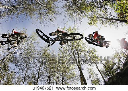 Under a series of bikers mid-jump; Canada Olympic Park, Calgary, AB View Large Photo Image Stock Image - Under a series of bikers mid-jump; Canada Olympic Park, Calgary, AB. Fotosearch