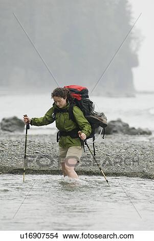 Woman (20-25) crossing a fast-flowing creek with a large backpack on, West Coast Trail, Pacific Rim National Park Reserve, BC View Large Photo Image Picture - Woman (20-25) crossing a fast-flowing creek with a large backpack on, West Coast Trail, Pacific Rim National Park Reserve, BC. Fotosearch