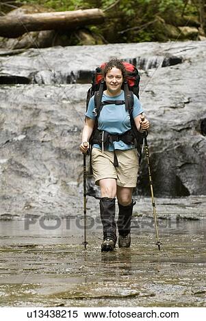 Stock Photography - Woman (20-25) hiking along a sandstone creek bed in an old-growth coastal forest, West Coast Trail, Pacific Rim National Park Reserve, BC. Fotosearch