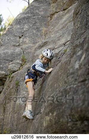 Stock Photograph - Young girl (age 7) climbing on granite cliff at Stone Hills near Rexford, Montana, USA. Fotosearch