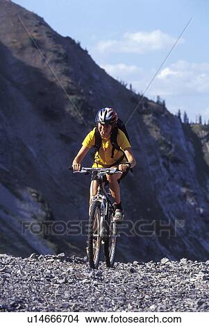 Picture - Young woman mountain biking at Fernie Alpine Resort, Fernie, BC, Canada. Fotosearch