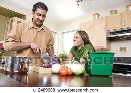 Couple in kitchen cutting vegetables beside kitchen compost bin, Winnipeg, Canada View Large Photo Image Stock Photo - Couple in kitchen cutting vegetables beside kitchen compost bin, Winnipeg, Canada. Fotosearch