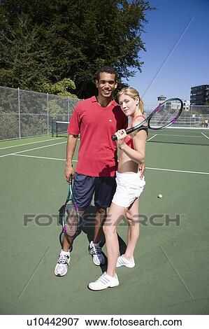 Stock Photo - Couple on tennis court; Canada, British Columbia, Vancouver. Fotosearch