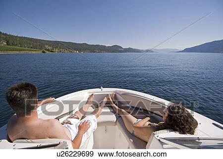 Stock Photo - Relaxing on four-stroke engine boat, Okanagan Centre, BC Canada.. Fotosearch