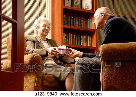 Stock Image - Senior Woman with gift; Canada, Saskatchewan, Regina. Fotosearch