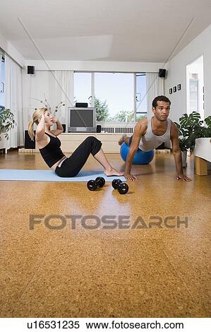 Young couple exercise at home, performing sit-ups and push-ups, Vancouver, British Columbia View Large Photo Image Stock Photography - Young couple exercise at home, performing sit-ups and push-ups, Vancouver, British Columbia. Fotosearch