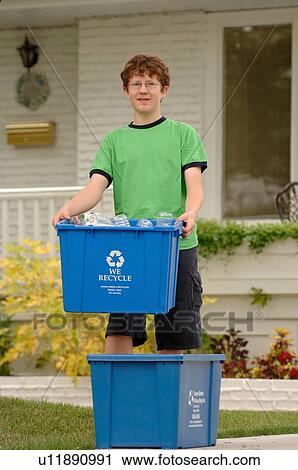 Stock Image - Boy taking recycling to curb, Regina, Saskatchewan. Fotosearch