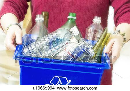 Picture - Homemaker taking out "Blue Bin" full of bottles and cans for recycling.. Fotosearch