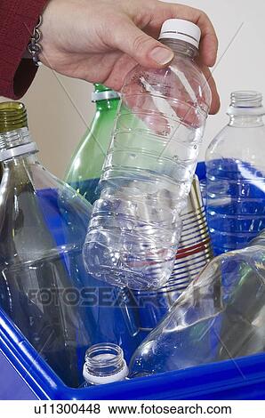 Stock Photo - Homemaker taking out "Blue Bin" full of bottles and cans for recycling.. Fotosearch
