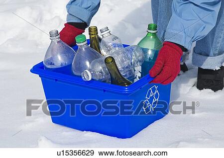 Stock Photo - Homemaker taking out "Blue Bin" full of bottles and cans for recycling.. Fotosearch