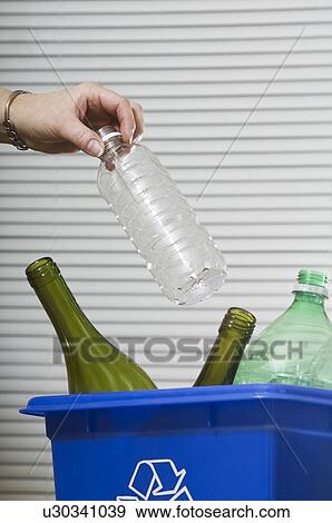Stock Photo - Homemaker taking out "Blue Bin" full of bottles and cans for recycling.. Fotosearch