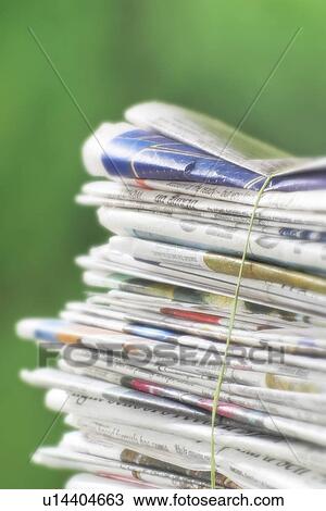 Stock Image - Newspapers tied into a pile for the recycle bin.. Fotosearch