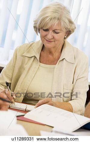Stock Image - Adult student studying at table. Fotosearch