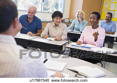 Stock Image - Adult students in class with teacher (selective focus). Fotosearch