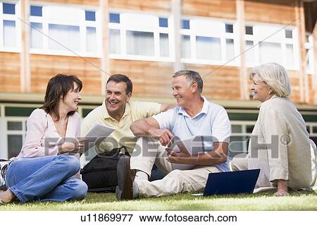 Adult students on lawn of school studying and talking View Large Photo Image Stock Photo - Adult students on lawn of school studying and talking. Fotosearch
