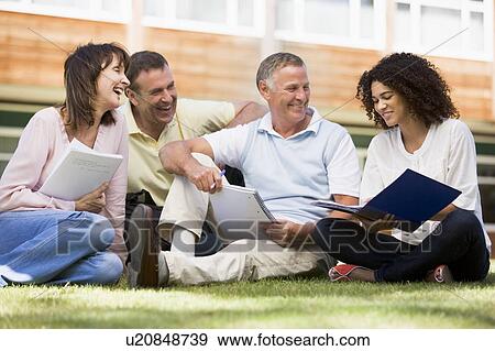 Adult students on lawn of school studying and talking View Large Photo Image Stock Photo - Adult students on lawn of school studying and talking. Fotosearch